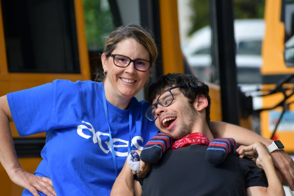 ACES Whitney Academy teacher and student in front of school bus