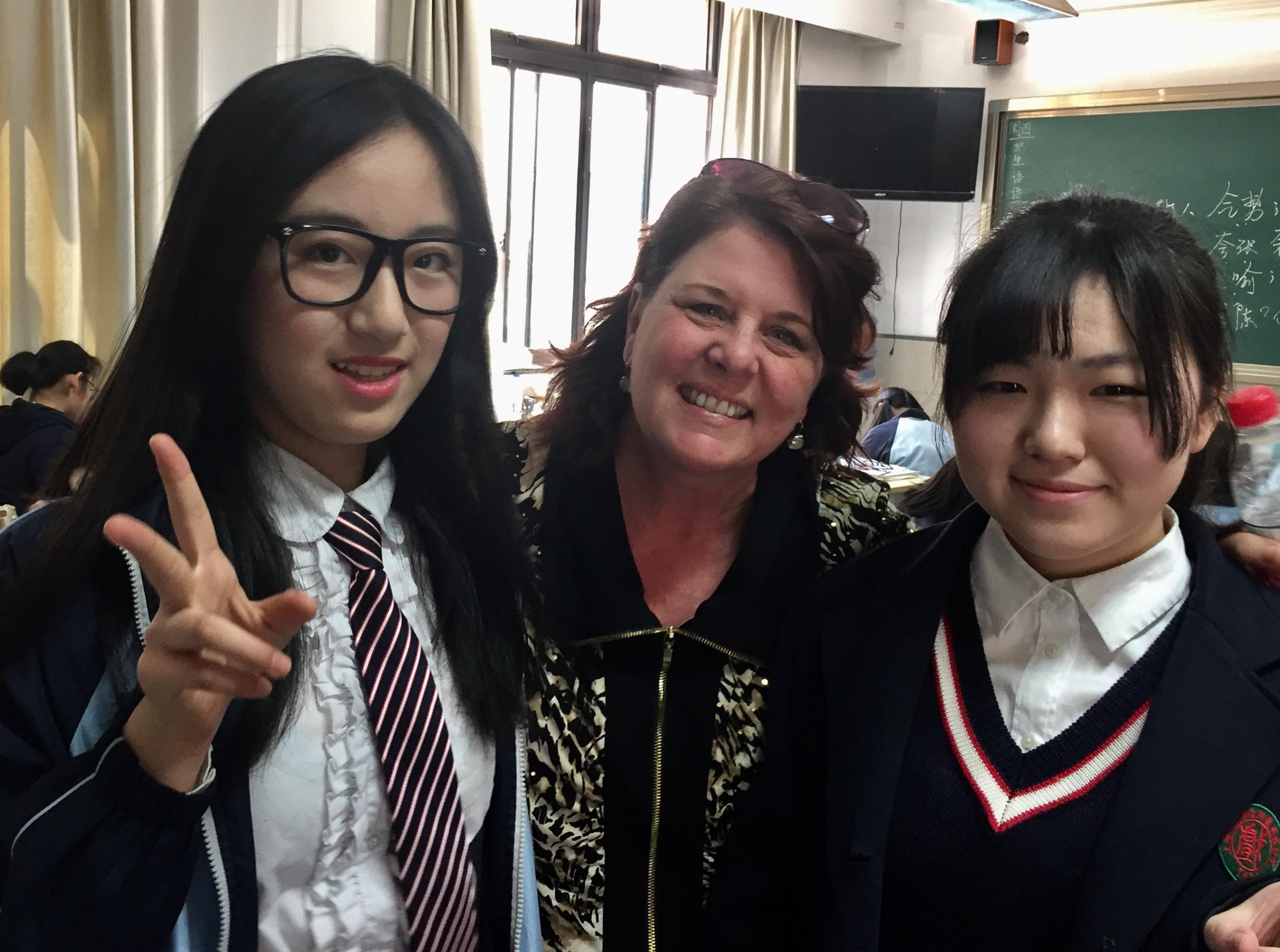 An educator on the field study to China takes a picture with two students from Shaanxi Normal University. 
