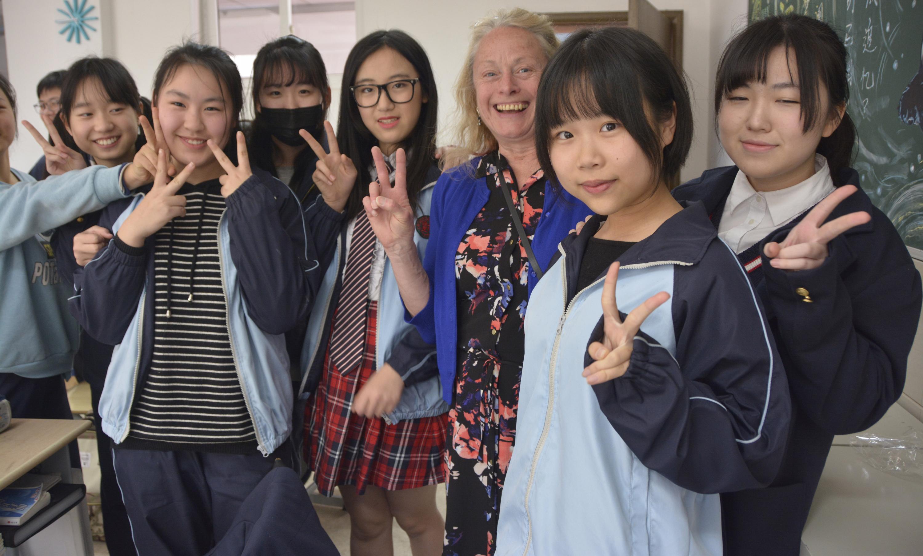 An educator on the field study to China poses for a photo with a group of students from Shaanxi Normal University.