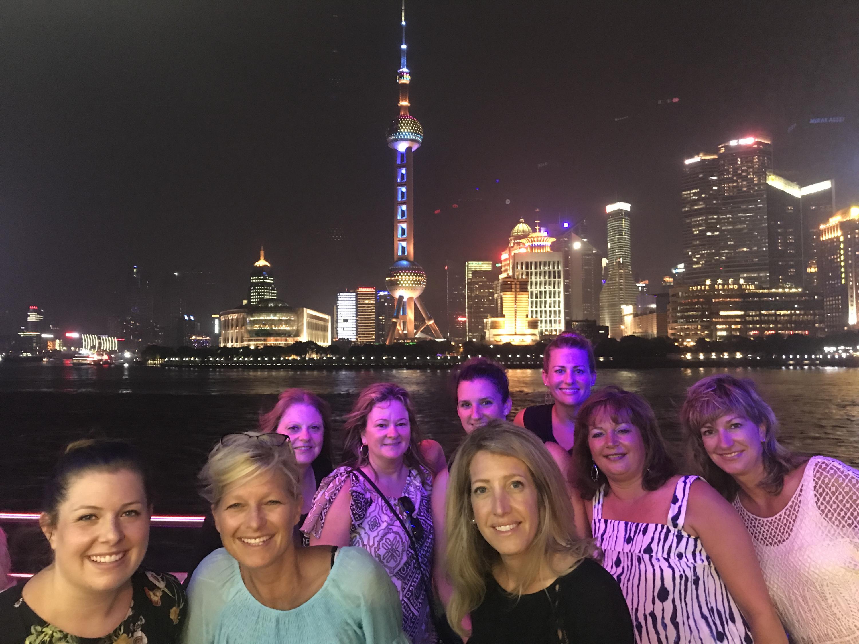 ACES ECA educators pose for a photo in front of the Shanghai Oriental Pearl Tower at night.