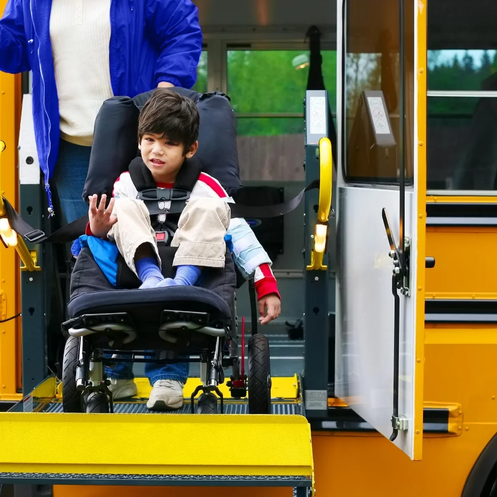 student in wheelchair being lowered out of school bus